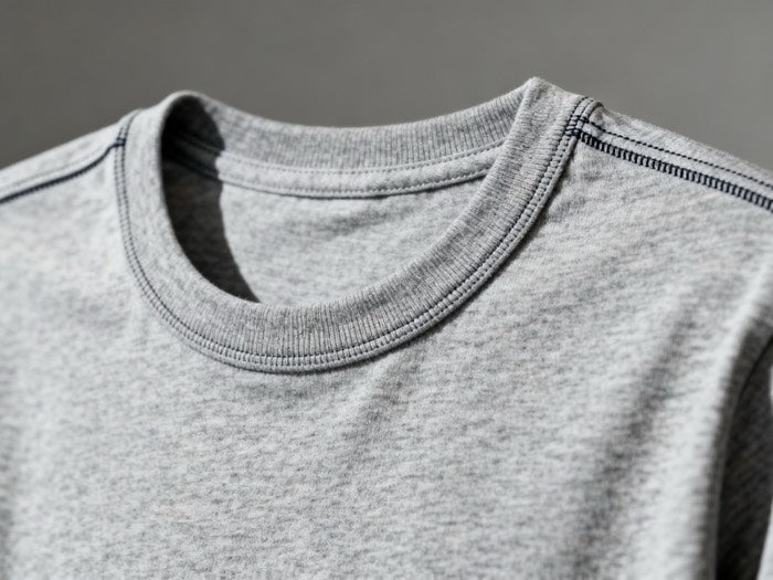 Close-up of the ribbed collar and shoulder seams on a gray T-shirt
