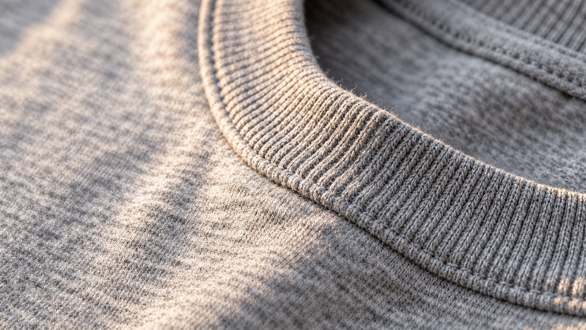 Close-up of a heather-grey cotton T-shirt ribbed collar and fine jersey texture.